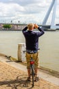 Man with bicycle photographing the Erasmus Bridge in Rotterdam Royalty Free Stock Photo