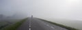 man on bicycle rides in mist on dike near river rhine in holland Royalty Free Stock Photo