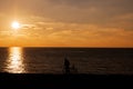 Man and bicycle silhouette at sunset sea