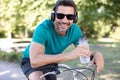 man on bicycle wearing headphones and holding bottle water
