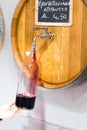 A man in a bid winery pouring wine from barrel in winebottle. One liter of wine. Vertical. Hand with winebottle