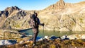 Man with big backpack hiking with a scenic view on the mountains of Hohe Tauern Alps in Carinthia, Austria, Europe. A lake and