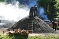 Man working on smoking charcoal-kiln