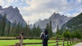 A man with a big hiking backpack enjoying the distant view on Italian Dolomites. There is a lush green meadow Royalty Free Stock Photo