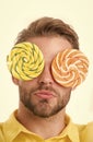 Man with big lollipops with hypnotizing pattern on eyes as eyeglasses. Hypnotized concept. Guy on calm face with giant Royalty Free Stock Photo