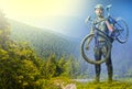 The man with bike in sand standing on mountains background. Collage Royalty Free Stock Photo