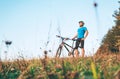 Man with bike stay on the top of hill and enjoying the sunset Royalty Free Stock Photo