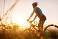 Man biker man meets a sunset in top of hill over the city. Active sport people concept image