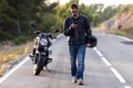 Man biker walking on the road while using her mobile phone after having suffered a breakdown on the road Royalty Free Stock Photo