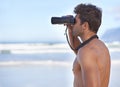 Man, binoculars and lifeguard on beach in search or checking danger for health and safety. Face of male person in Royalty Free Stock Photo