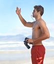 Man, binoculars and lifeguard on beach with whistle in security, emergency or health and safety. Young male person Royalty Free Stock Photo