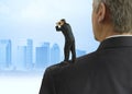Man with binoculars looking into the distance standing on the shoulders of giants concept with cityscape background Royalty Free Stock Photo