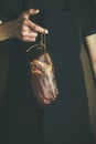 Man in black apron holding cut of cured pork Royalty Free Stock Photo