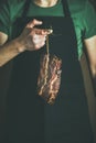 Man in black apron keeping cut of cured pork meat Royalty Free Stock Photo