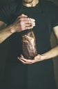 Man in black apron keeping cut of cured pork Royalty Free Stock Photo