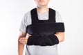 A man in a black bandage supporting the shoulder joint after ligament damage and bruise. Dislocation of the shoulder