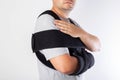 A man in a black bandage supporting the shoulder joint after ligament damage and bruise. Dislocation of the shoulder