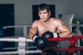 Man in black boxing gloves on the ropes of the ring is worth. Recreation. Portrait strong-willed person. Royalty Free Stock Photo