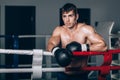 Man in black boxing gloves on the ropes of the ring is worth. Recreation. Portrait strong-willed person. Royalty Free Stock Photo
