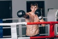 Man in black boxing gloves on the ropes of the ring is worth. Recreation. Portrait strong-willed person. Royalty Free Stock Photo