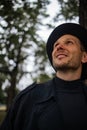 Portrait of young english man in stylish vintage coat and black hat walking in rainy forest looking up Royalty Free Stock Photo