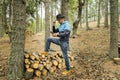 Man black cowboy hat taking a selfie on cell phone on pile wood logs in beautiful forest landscape.Male using smartphone in nature Royalty Free Stock Photo