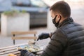 Man in black face mask sitting in cafe and prepared for eating vegan salad. Quarantine cafe concept. Covid-19 Royalty Free Stock Photo