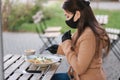 Man in black face mask sitting in cafe and prepared for eating vegan salad. Quarantine cafe concept. Covid-19 Royalty Free Stock Photo