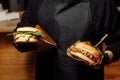 Man Black Gloves Holding Burger Hands Juicy Burger Close Appetizing burger.