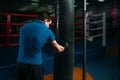 Man in black handwraps exercises with bag in gym