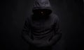 Man in Black Hood in dark studio. Boy in a hooded sweatshirt Royalty Free Stock Photo