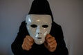 Man with black hooded jacket holding a white mask Royalty Free Stock Photo