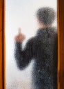 Man in black behind closed door through glass