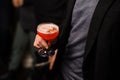 Man in black jacket holding a cocktail glass with sweet alcoholic drink Royalty Free Stock Photo