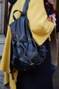 Man with black leather backpack and yellow cloak before Cedric Charlier fashion show, Milan Fashion Week