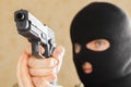 Man in black mask holding gun and ready to use it