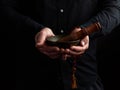 Man in a black shirt holds a Tibetan brass singing bowl and a wooden stick, a ritual of meditation Royalty Free Stock Photo