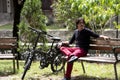 Man on park bench sitting next to electric bicycle Royalty Free Stock Photo