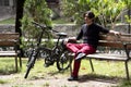 Man on park bench sitting next to electric bicycle Royalty Free Stock Photo