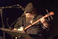 Man in black sits and plays shamisen