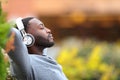 Man with black skin relaxing listening to music in a park Royalty Free Stock Photo