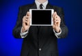 Man in a black suit holding a white tablet Royalty Free Stock Photo