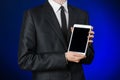 Man in a black suit holding a white tablet Royalty Free Stock Photo