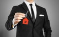 A man in a black suit holds the keys to the house. Key ring red Royalty Free Stock Photo