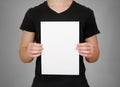 Man in black t shirt holding blank white A4 paper. Leaflet presentation. Pamphlet hold hands. Man show clear offset paper. Sheet Royalty Free Stock Photo