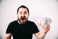 A man in a black t-shirt screams and shows off his cash prize in Euro dollars and rubles Royalty Free Stock Photo
