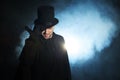 Man in a black top hat and cloak. Demonic image. Magician illusionist