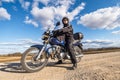 Man in a black uniform on bike against the backdrop of panorama of field and blue sky. motorcycle travel concept Royalty Free Stock Photo