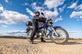 Man in a black uniform on bike against the backdrop of panorama of field and blue sky. motorcycle travel concept Royalty Free Stock Photo