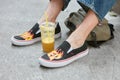 Man with black Vans shoes with flames design and orange juice before Emporio Armani fashion show, Milan Fashion